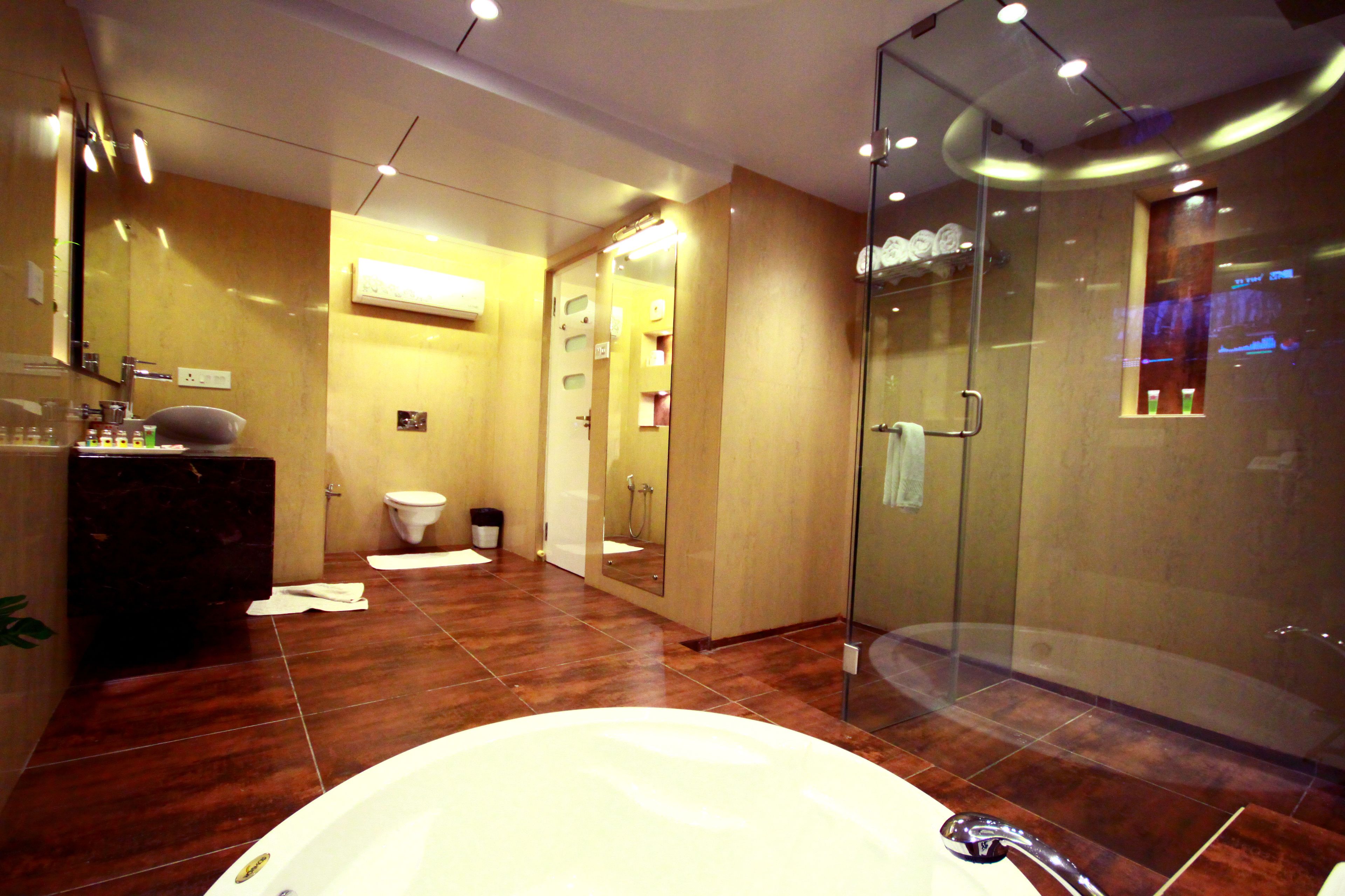 A modern bathroom with a large bathtub, a glass-enclosed shower, and a vanity with a mirror.
