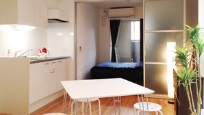 A compact room with a kitchenette, a small bed, and a dining area. - Stella Inn Karasuma Gojo (Kyoto)