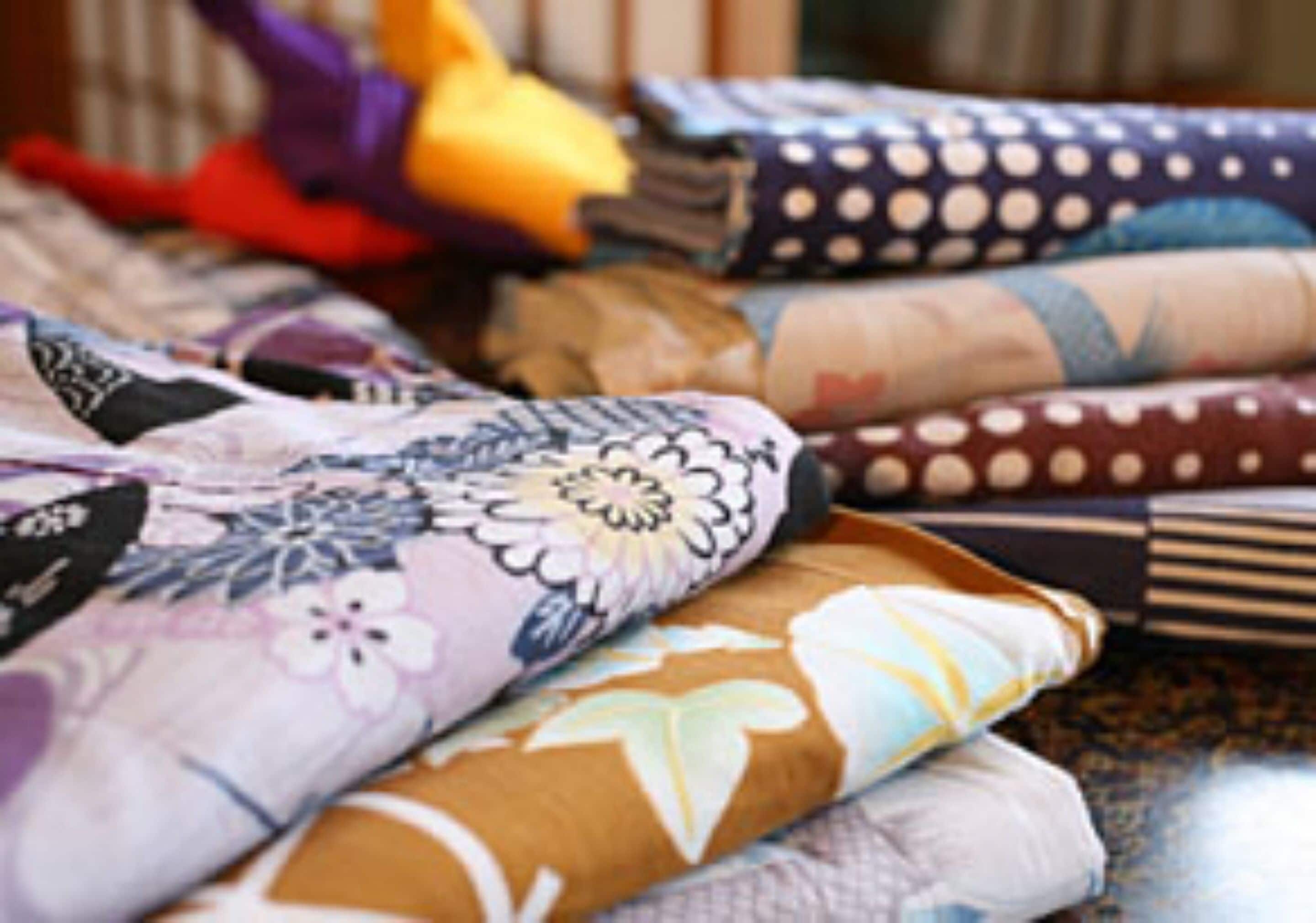 A variety of folded fabrics with floral and polka dot patterns.