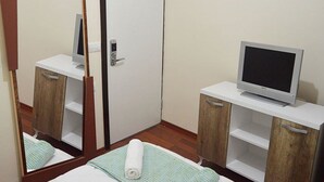 A hotel room with a bed, a television on a wooden cabinet, and a mirror reflecting the room. - Dilara Hotel (Antalya)