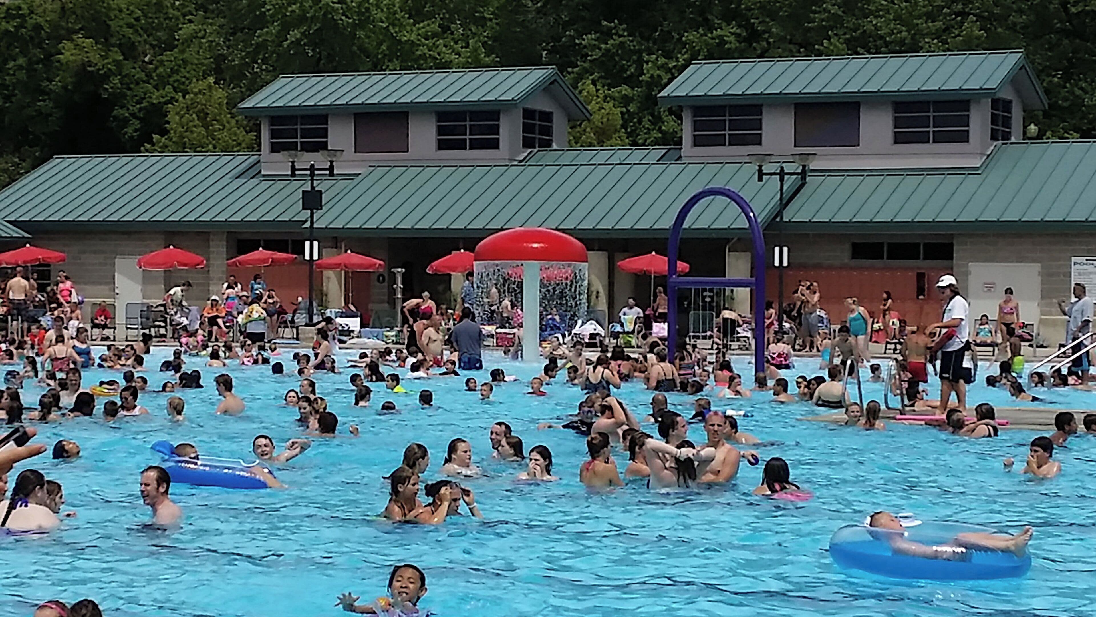 A public swimming pool with multiple lanes and a lifeguard stand.