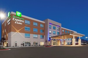 Un hotel Holiday Inn Express & Suites con un diseño moderno, que cuenta con una entrada destacada y una zona de estacionamiento techada.