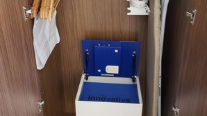 A compact bathroom with a built-in washing machine, a drying rack, and a shower hose. - Holiday Inn Express & Suites Brigham City - North Utah by IHG (Brigham City)