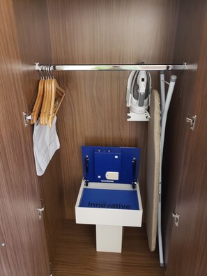 A compact bathroom with a built-in washing machine, a drying rack, and a shower hose. - Holiday Inn Express & Suites Brigham City - North Utah by IHG (Brigham City)