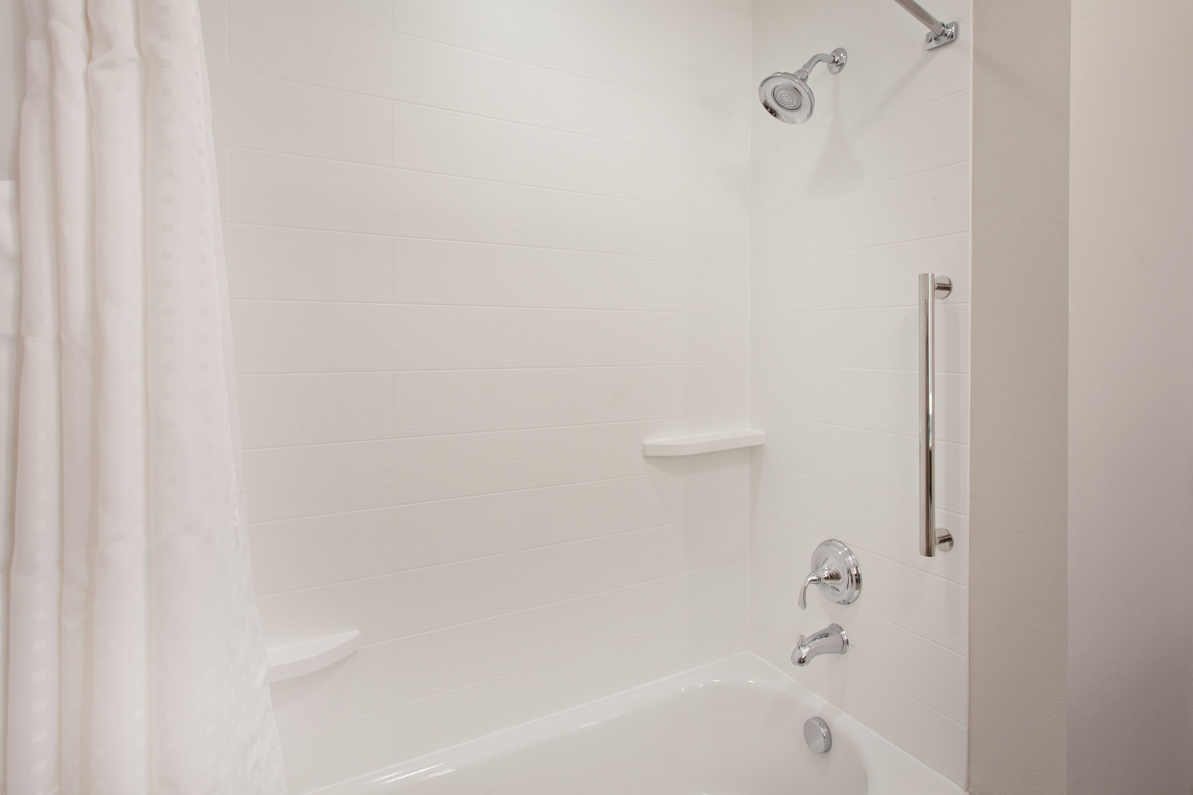 Une salle de bain blanche avec une baignoire, une douche et des toilettes.