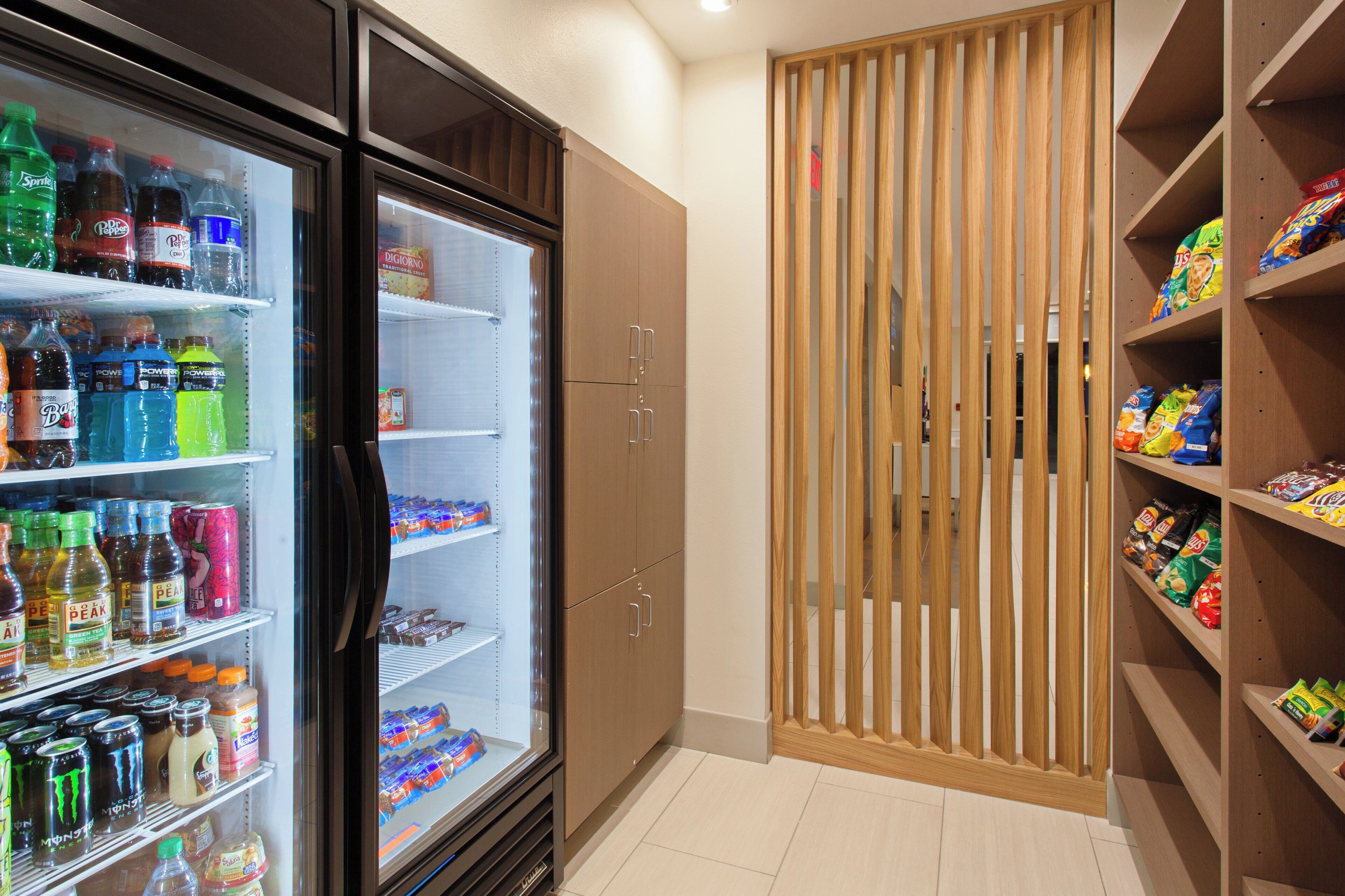 A refrigerated beverage display with various drinks and a wooden partition.