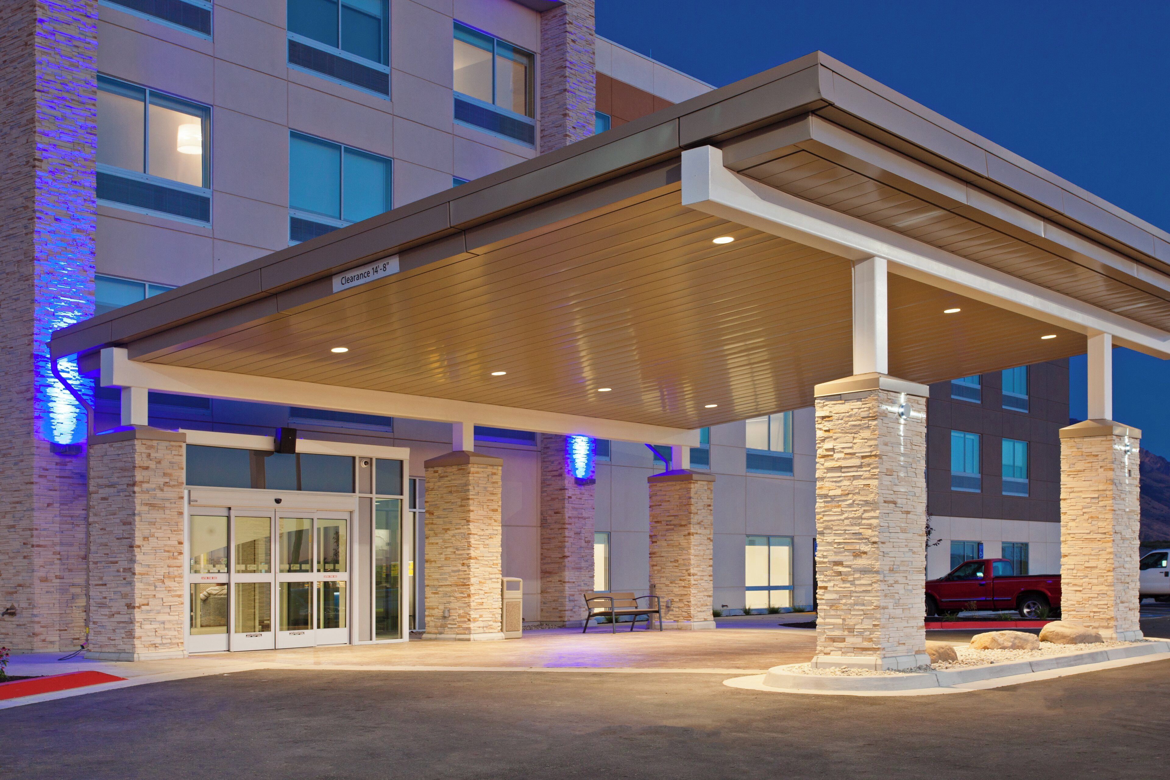A hotel entrance with a covered waiting area, stone pillars, and a clear sign indicating a 14'-8' clearance.