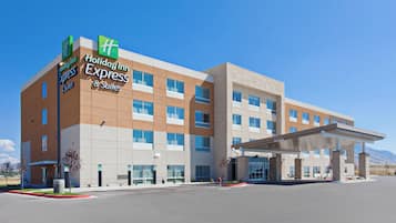 A Holiday Inn Express & Suites hotel with a modern design, featuring a flat roof and a covered entrance.