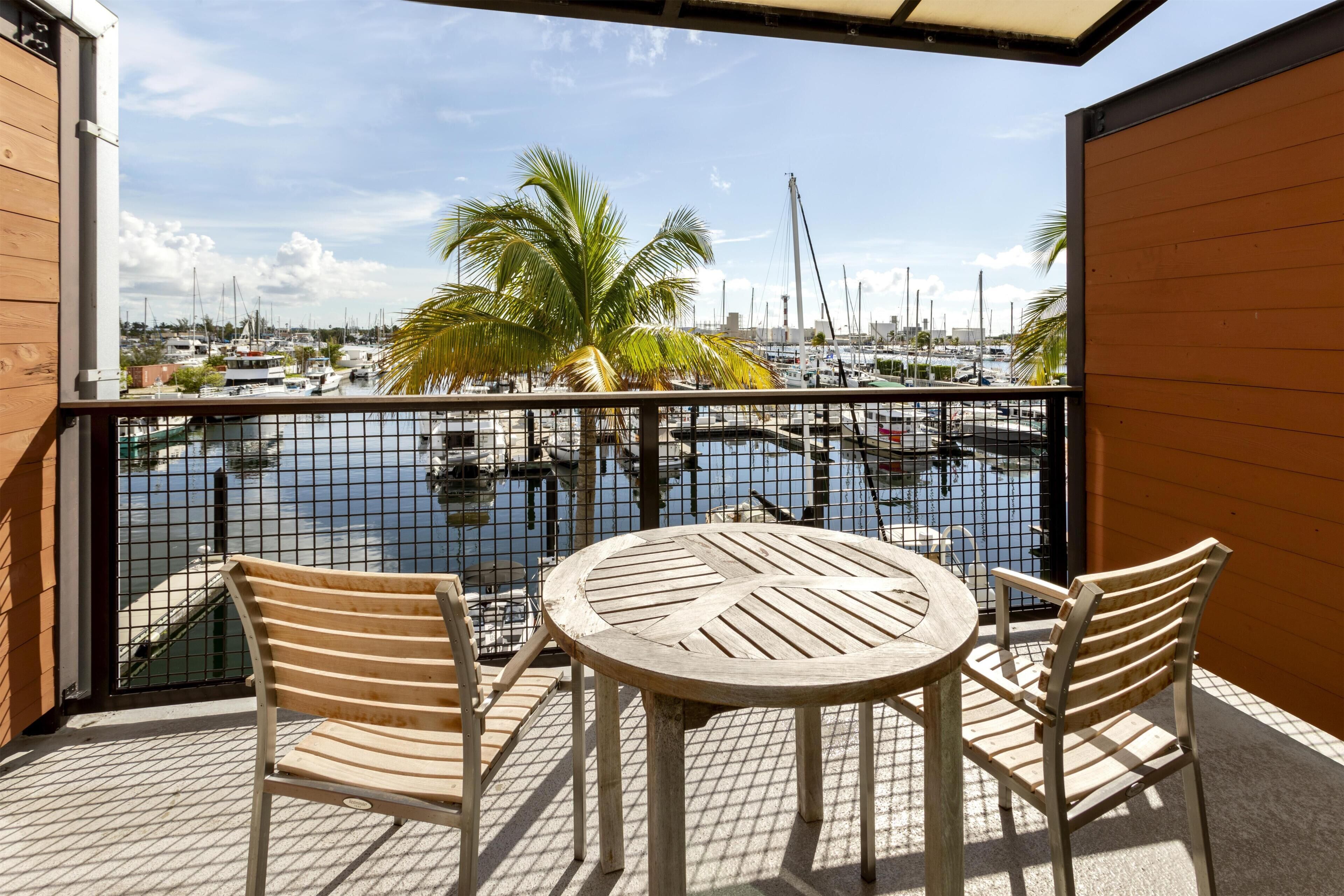 Un balcone con vista su una marina, con un tavolo e due sedie.