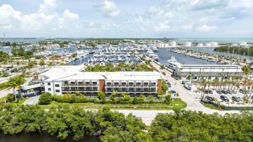 A marina with numerous boats, a modern building with large windows, and a view of the ocean.
