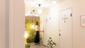 A hotel room with a moss-covered wall, a yellow toilet, and a door labeled "1 room 5".