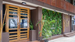 A building entrance with a wooden door, a green vertical garden, and a sign reading "INORVA". - The Vinorva Maldives (Vilimalé)