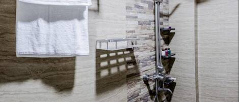 A bathroom with a shower, a towel rack, and a shelf with toiletries.