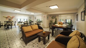 Un hall de hotel espacioso con comedor, asientos y una recepción.