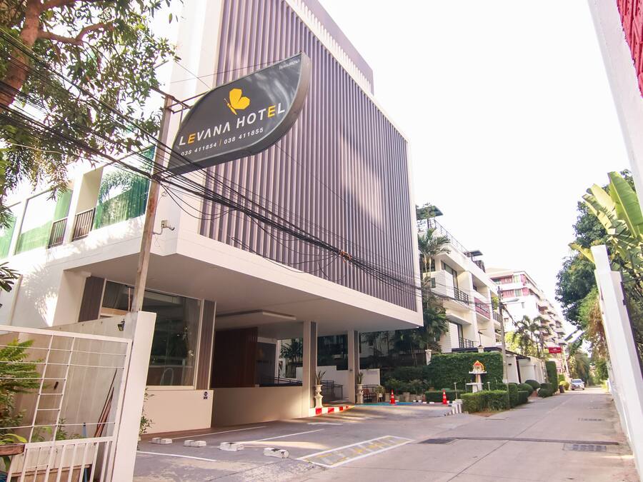 A modern hotel building with a sign reading "LEVANA HOTEL" and a contact number.