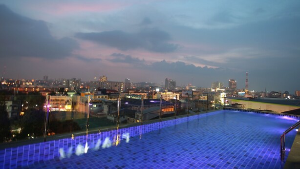 A rooftop pool with a cityscape view at dusk. - Levana Pattaya Hotel (Pattaya)