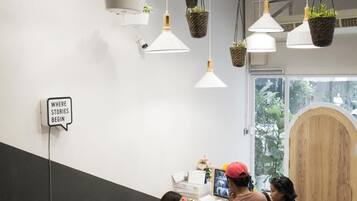 Un área de recepción con un mostrador, plantas colgantes y un cartel que dice "WHERE STORIES BEGIN".