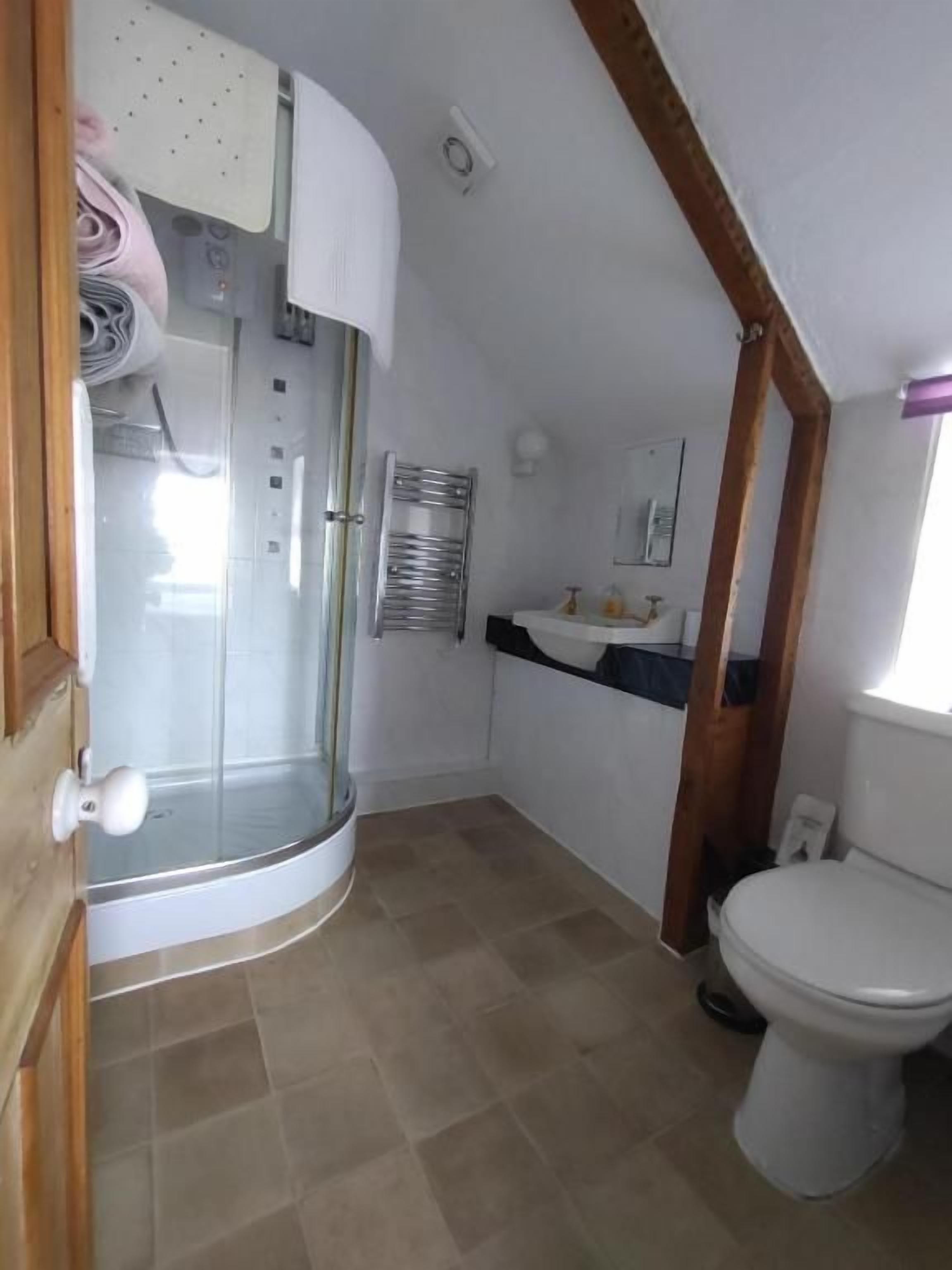 Un bagno con doccia, WC e lavandino.
