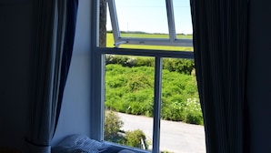 Ein Zimmer mit Fensterblick auf eine grüne Landschaft.