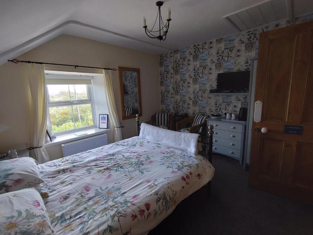 A bedroom with a bed, a dresser, a chair, and a window.