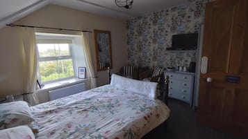 A bedroom with a bed, a dresser, a chair, and a window.