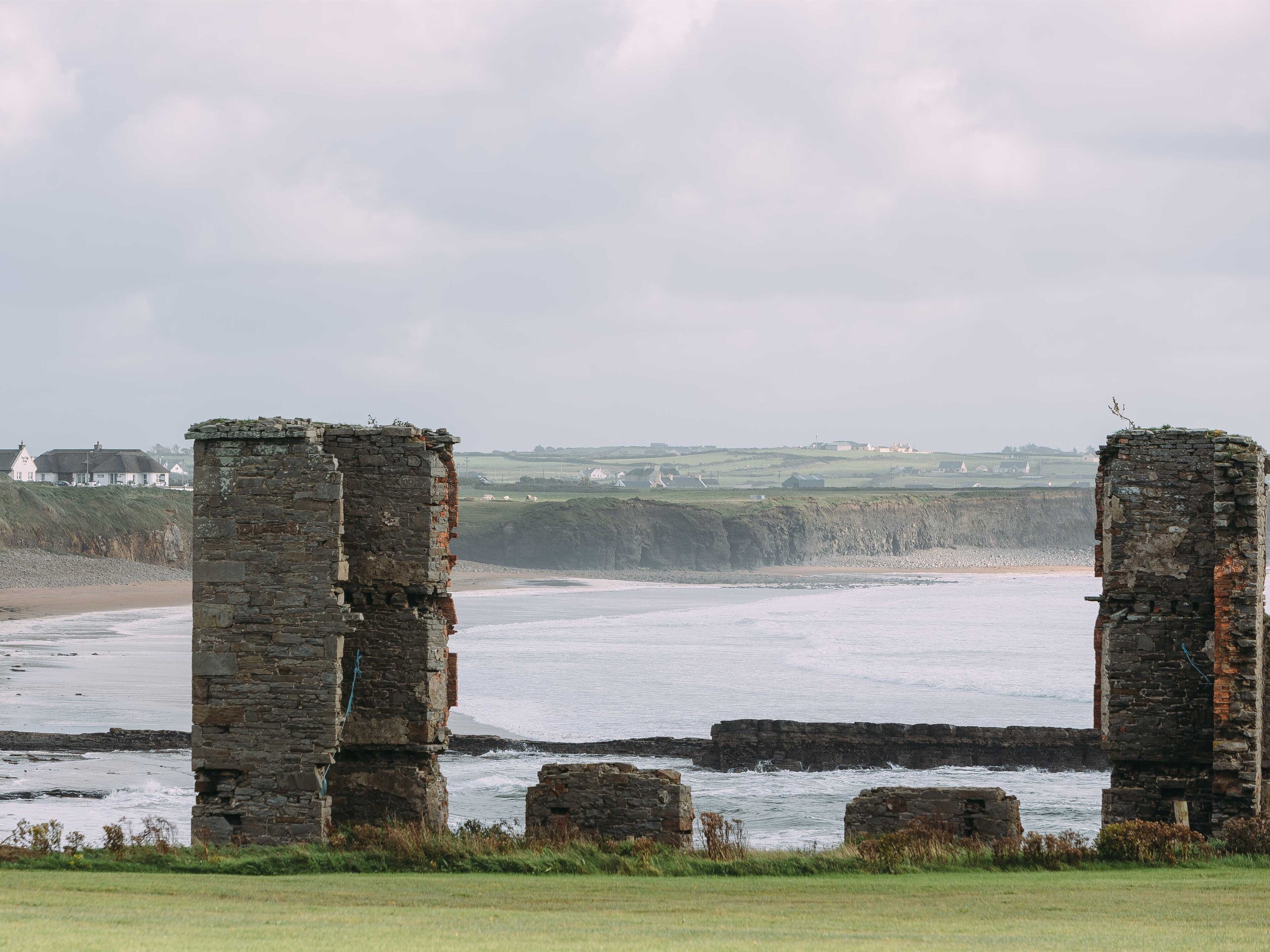 A coastal scene with stone ruins and a beach.