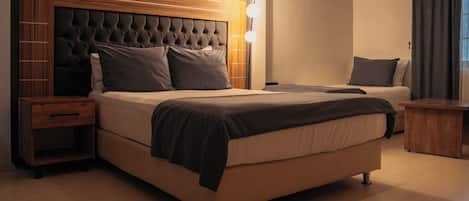 A bedroom with a large bed, bedside tables, a wooden headboard, and a wall-mounted air conditioner.