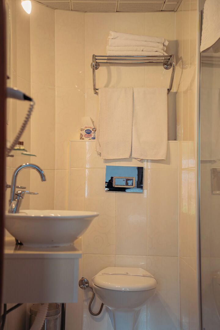 A bathroom with a sink, toilet, and a towel rack.