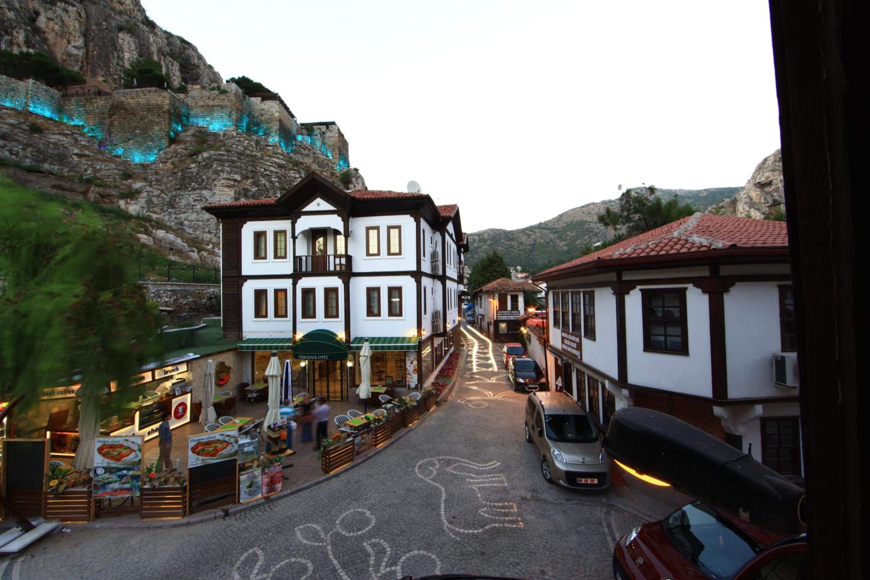 A street with buildings, a café, and a car.