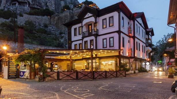 Een hotel in traditionele Europese stijl, met een gevel van natuursteen en een balkon.