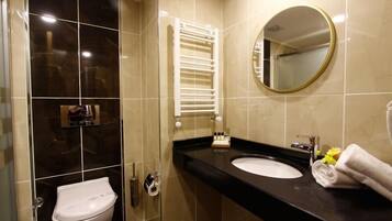 Een moderne badkamer met toilet, wastafel, spiegel en handdoekhouder.