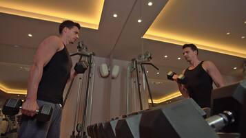 A gym with exercise equipment and mirrors.