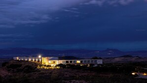 Una casa moderna con techo plano, ventanas grandes y una entrada bien iluminada.