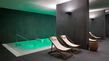 A spa area with a hot tub, two lounge chairs, and a woven basket on the floor.