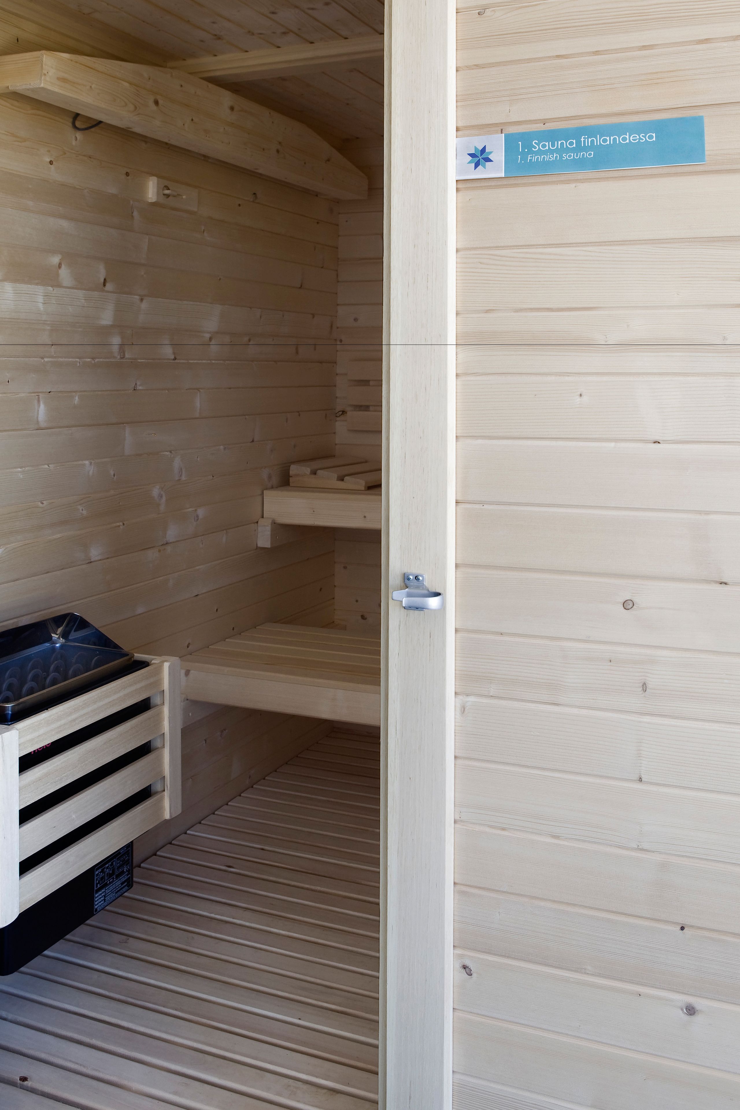 Un cuarto de sauna con paredes de madera y un cartel que indica que es una sauna finlandesa.