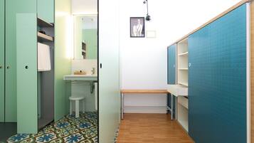 Un baño con piso estampado, un lavamanos y un espejo.