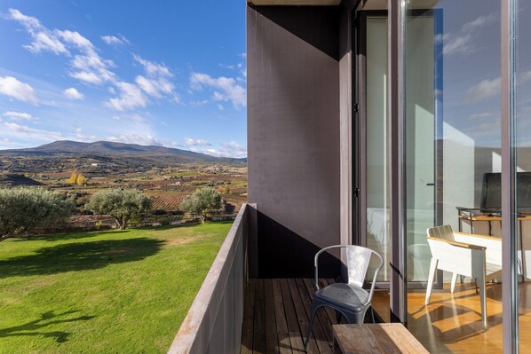 A balcony with a view of a grassy landscape and distant hills. - Hotel Bodega Finca de Los Arandinos (Entrena)