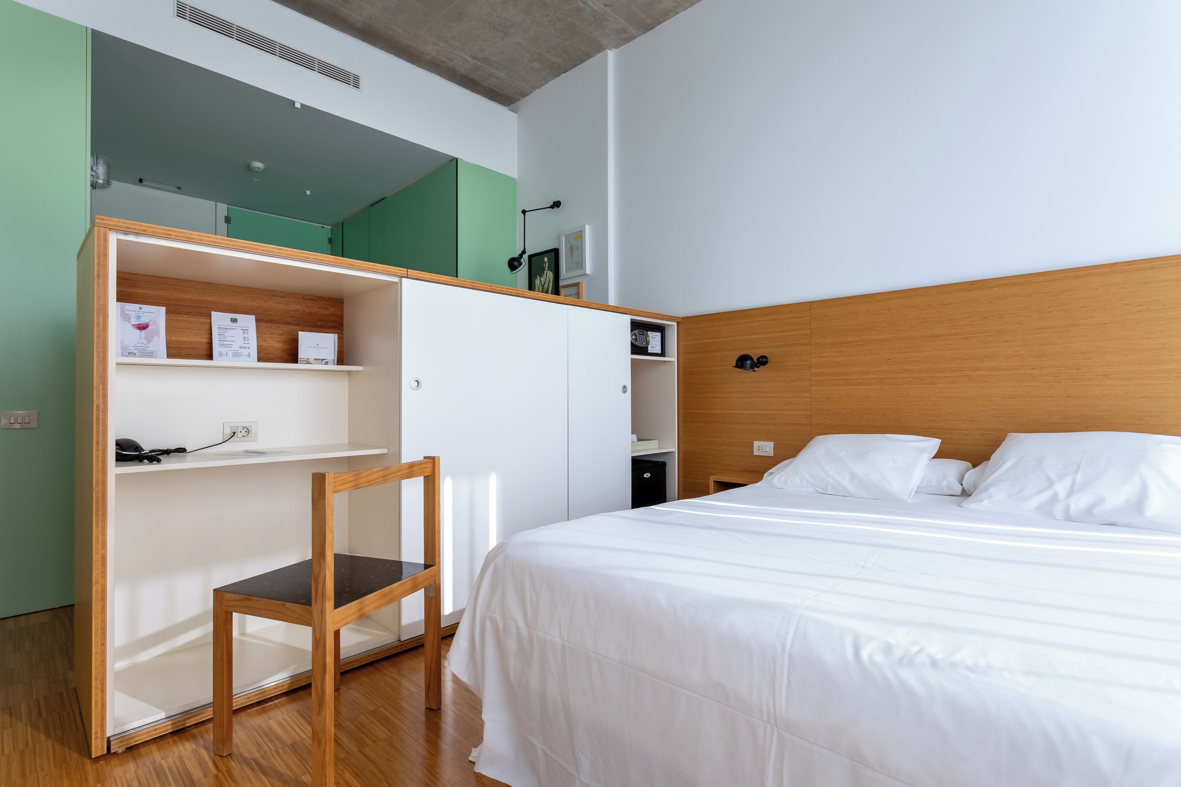 Un dormitorio con una cama, un escritorio y una silla.