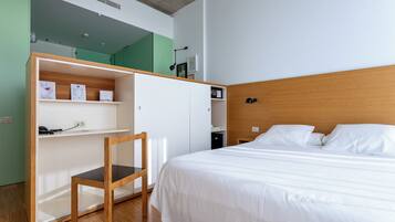 Un dormitorio con una cama, un escritorio y una silla.