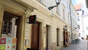 A building with a sign indicating a free WiFi spot, a wooden door, and a small outdoor seating area with tables and chairs.