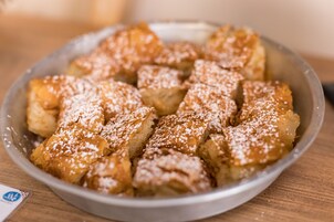 Un plato de pudín de pan cubierto de azúcar glas.