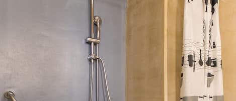 A bathroom with a shower, a towel rack, and a toilet.