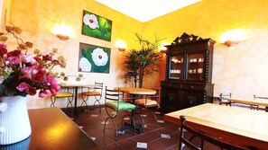 Un comedor con una mesa y sillas de madera, un armario y luces fijadas a la pared.