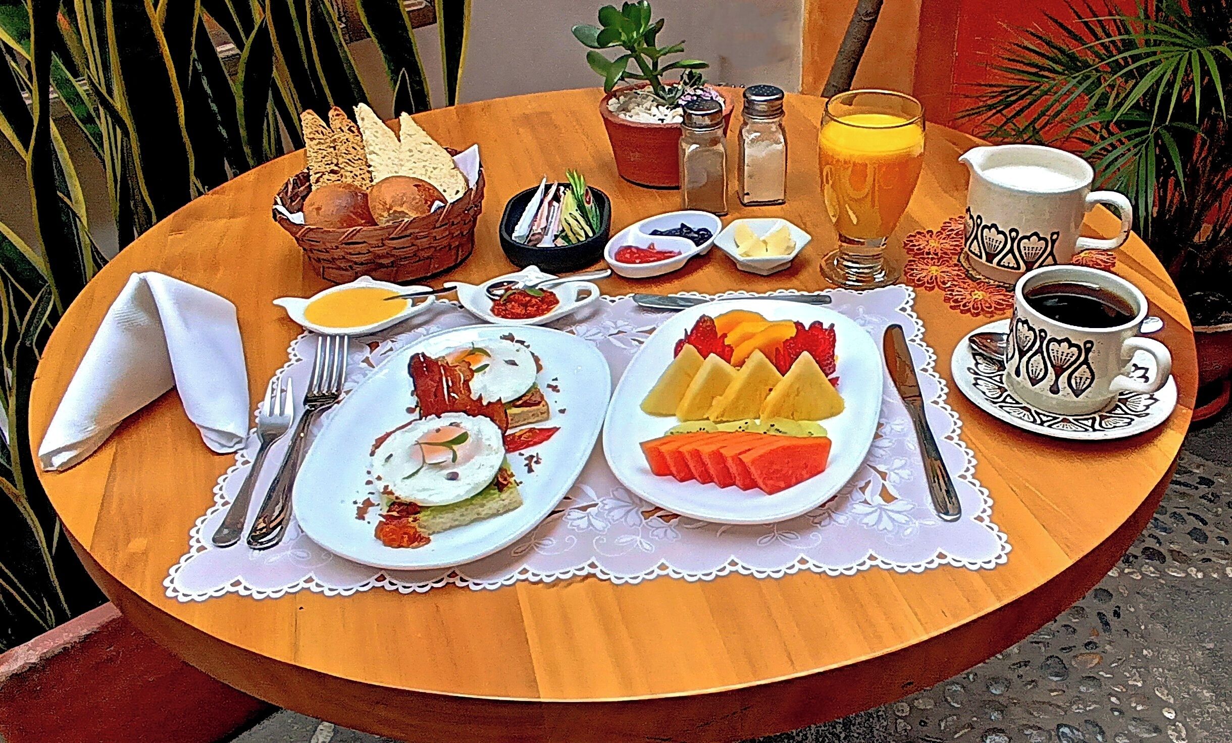A table set with breakfast including toast, eggs, fruit, coffee, and juice.