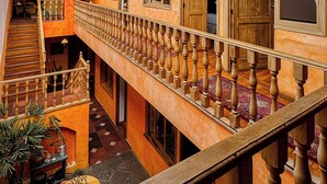 A multi-level interior with wooden balconies, a staircase, and a glass ceiling. - Hotel Boutique Casa Montalvo Cuenca (Cuenca)