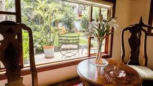 A room with a large window, wooden furniture, and a potted plant. - Hotel Boutique Casa Montalvo Cuenca (Cuenca)