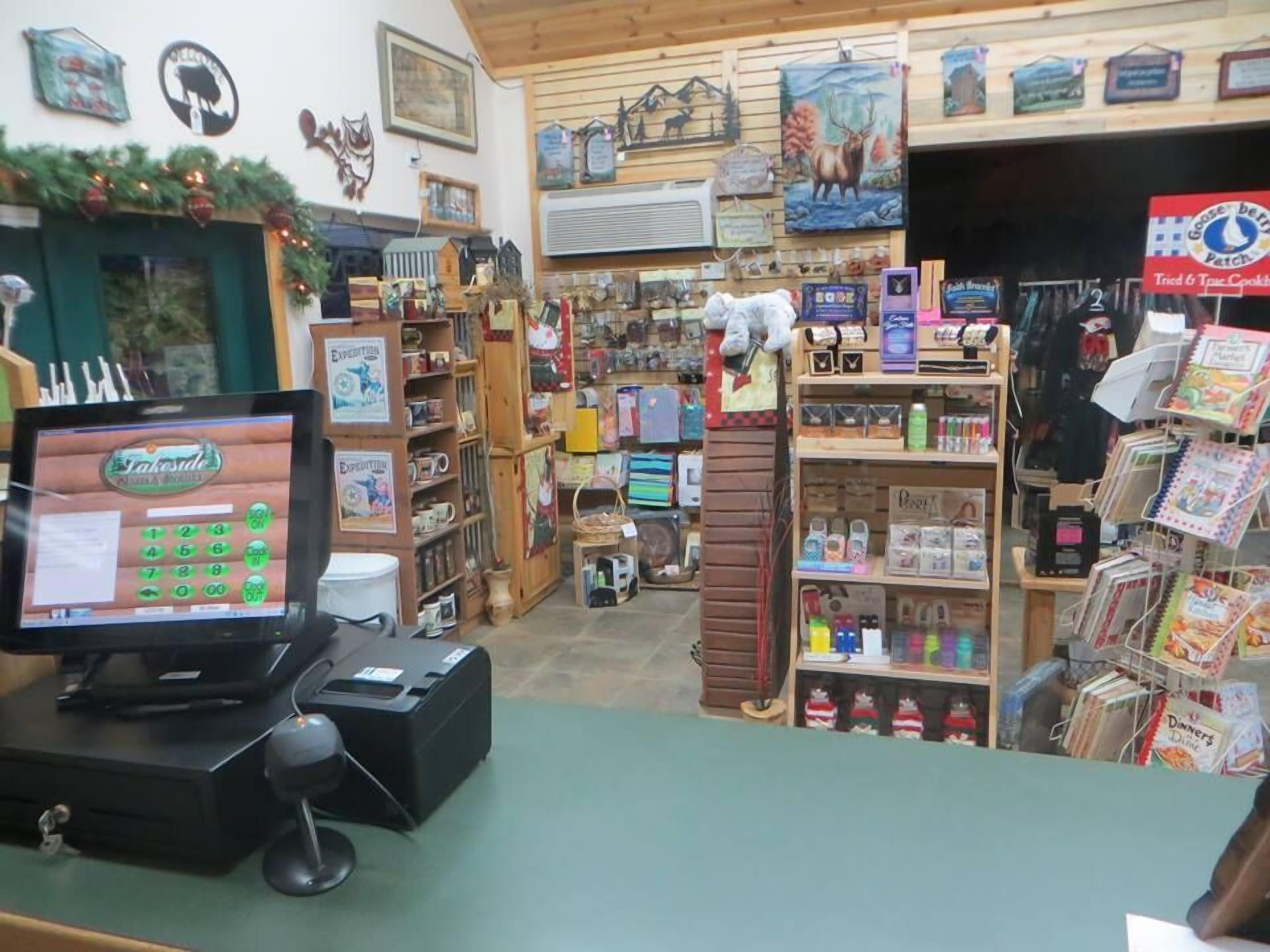 A small, cozy store with wooden shelves and a variety of items for sale, including books and decorative objects.