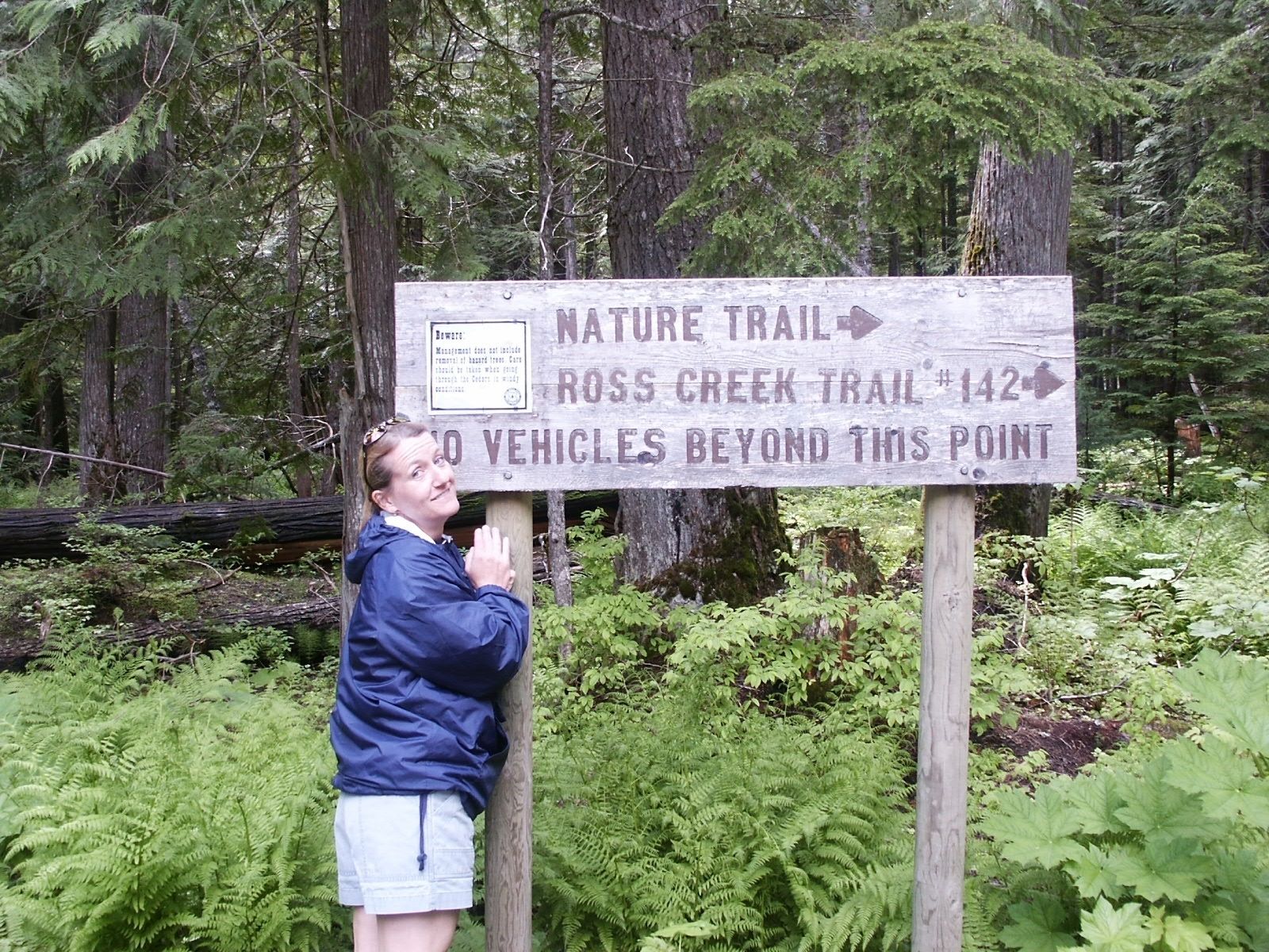 A signpost with directions for Nature Trail and Ross Creek Trail, and a warning about vehicle access.