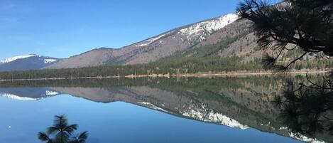 Un lago tranquillo con i riflessi di montagne e alberi.