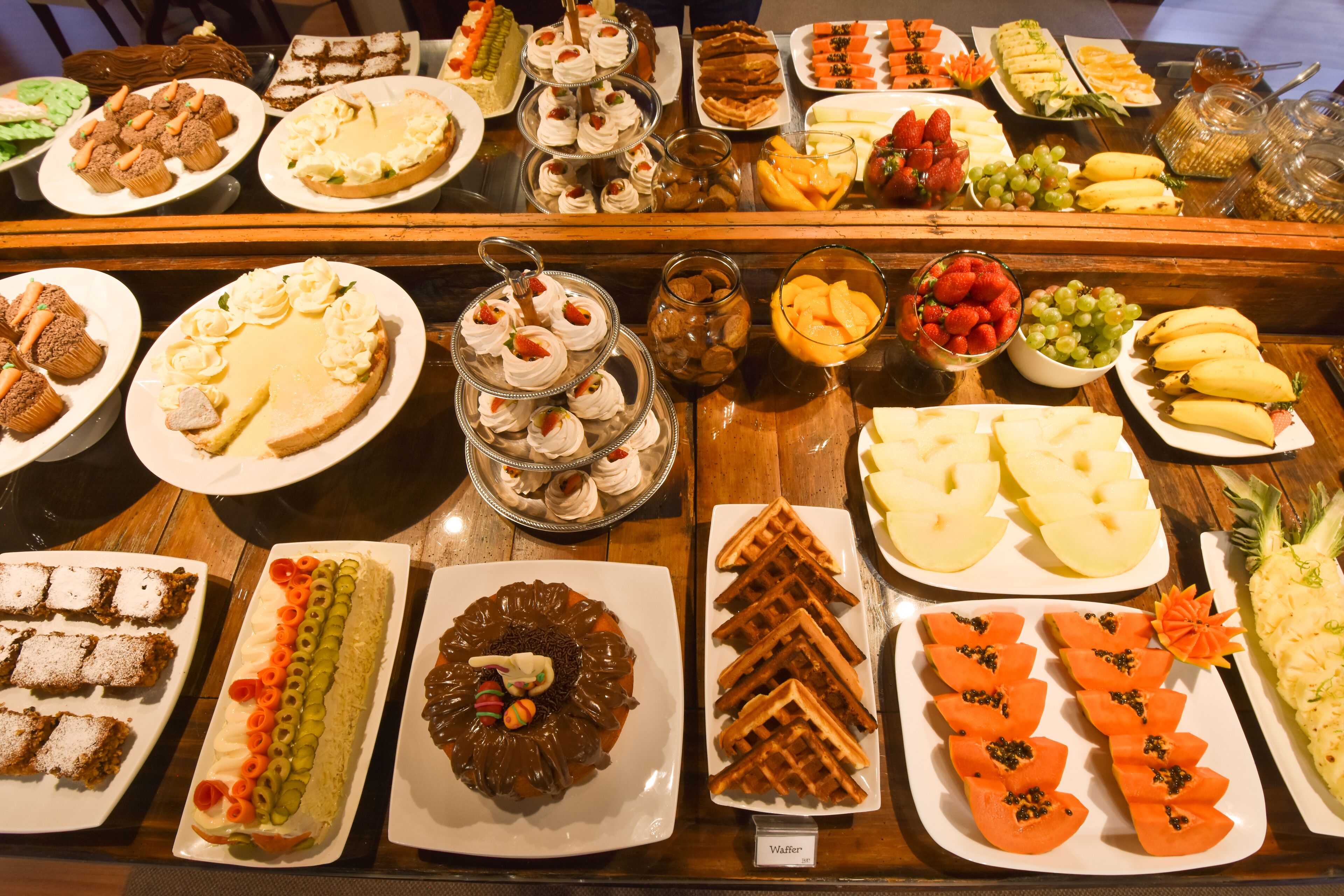 A buffet with various desserts and fruits.